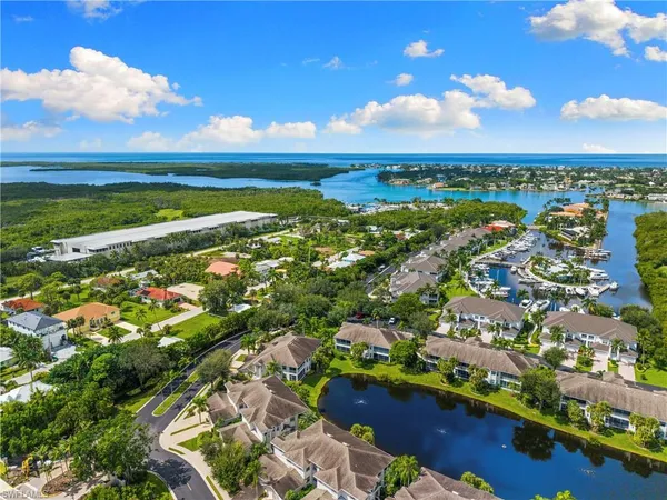 an aerial view of ocean and residential houses with outdoor space