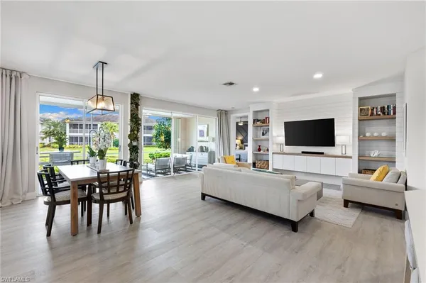 a living room with furniture flat screen tv and a large window