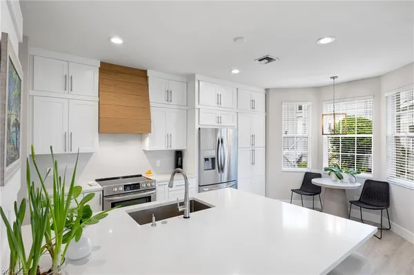 a kitchen with stainless steel appliances a sink a refrigerator a counter top space and a window