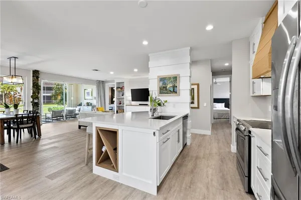 a large kitchen with stainless steel appliances a lot of counter space and a wooden floors