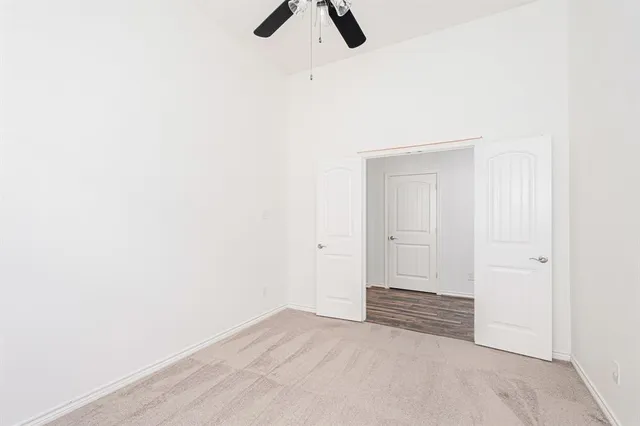 a view of a room with a ceiling fan and wooden floor