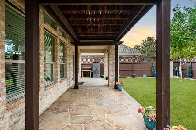 a view of a backyard with table and chairs and a large tree