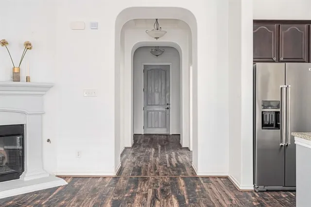 a view of a hallway with wooden floor and a fireplace