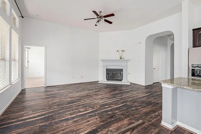 a view of empty room with a fireplace and wooden floor