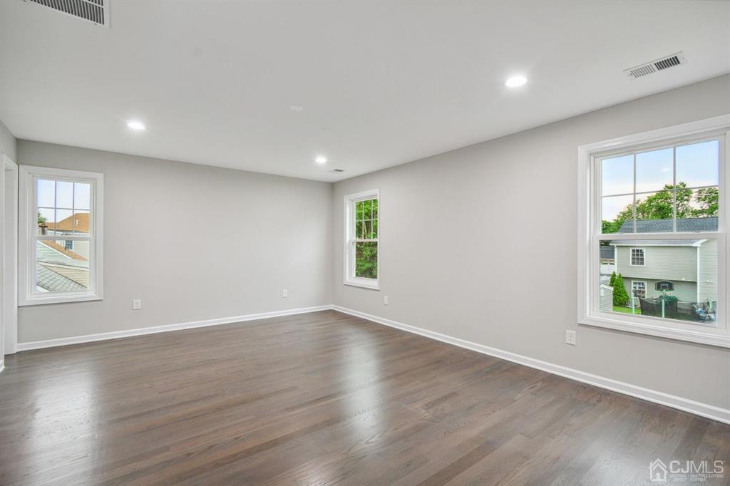 109 Idlewild Road Edison, NJ 08817 - Photo 12 of 15 an empty room with wooden floor and windows