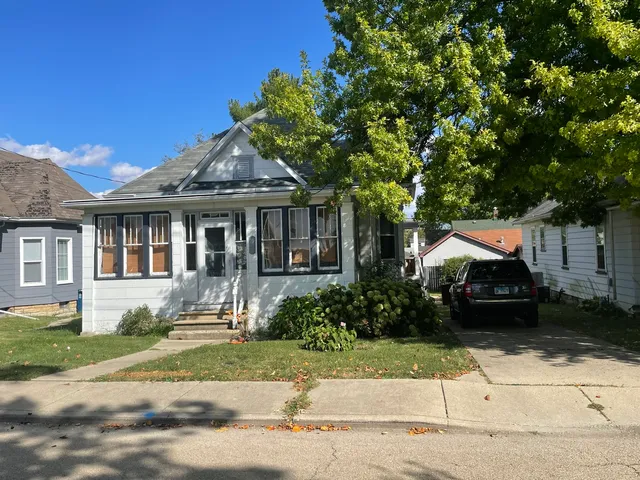a front view of a house with a garden and plants