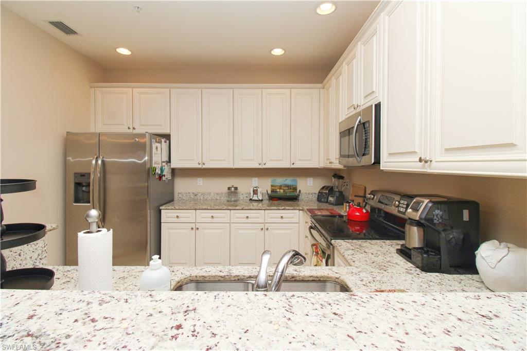 9054 Capistrano Street North, Unit 4003 Naples, FL 34113 - Photo 17 of 49 a kitchen with a sink cabinets and appliances