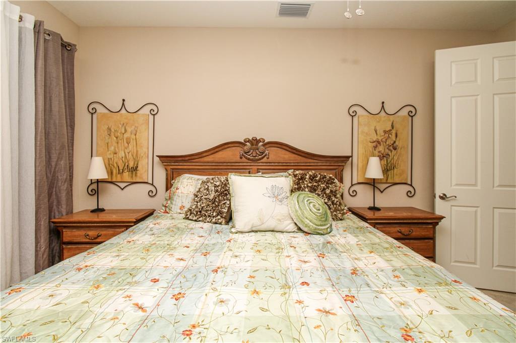 9054 Capistrano Street North, Unit 4003 Naples, FL 34113 - Photo 21 of 49 a bedroom with a bed and painting on the wall