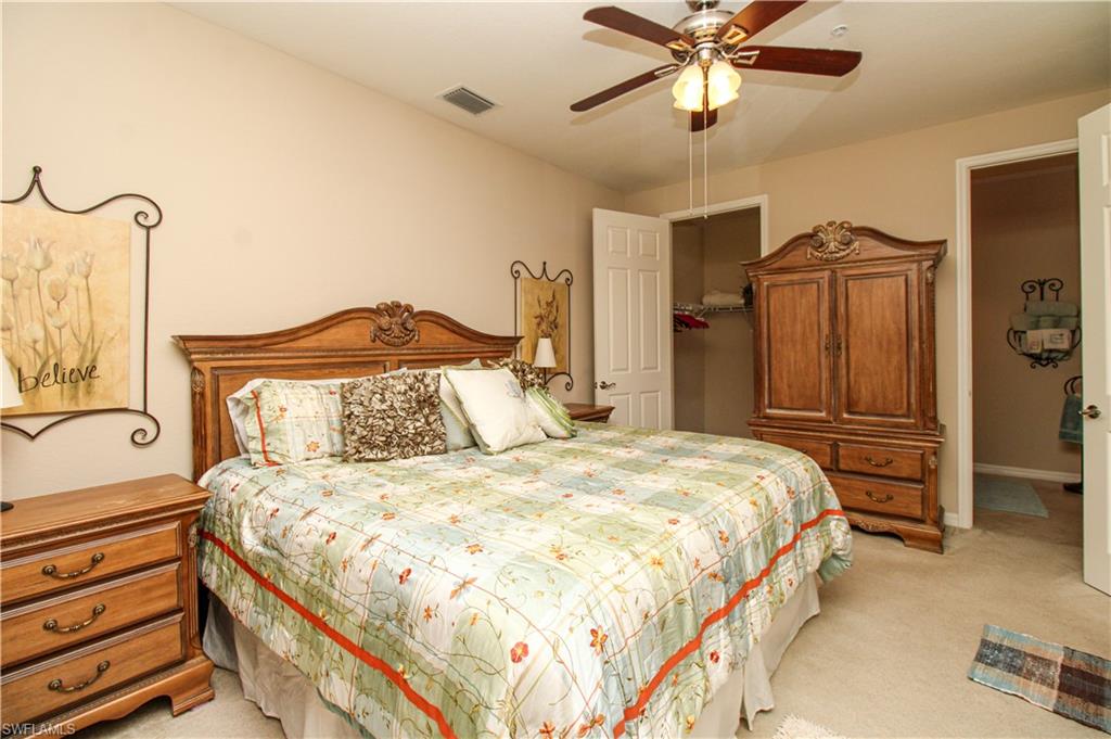 9054 Capistrano Street North, Unit 4003 Naples, FL 34113 - Photo 23 of 49 a bedroom with a bed and a chandelier