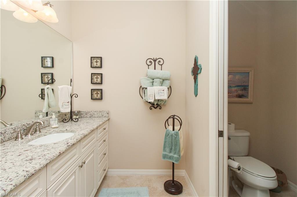 9054 Capistrano Street North, Unit 4003 Naples, FL 34113 - Photo 26 of 49 a bathroom with a granite countertop sink a toilet and a mirror