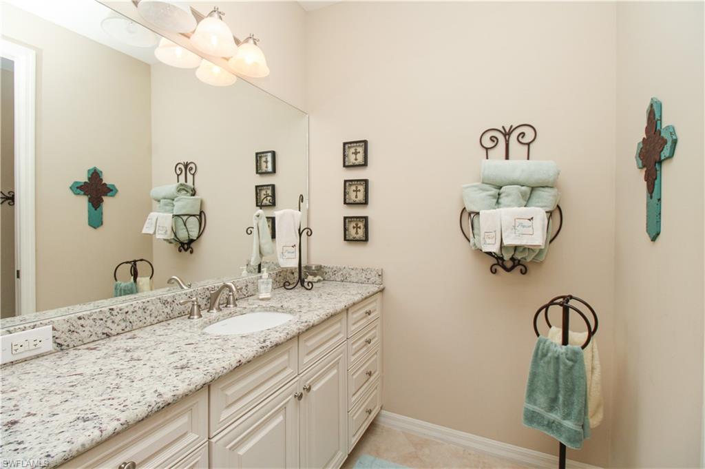 9054 Capistrano Street North, Unit 4003 Naples, FL 34113 - Photo 27 of 49 a bathroom with a granite countertop sink and a mirror