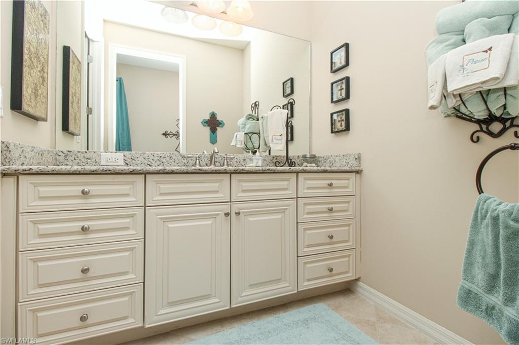 9054 Capistrano Street North, Unit 4003 Naples, FL 34113 - Photo 28 of 49 a bathroom with a granite countertop sink and a mirror