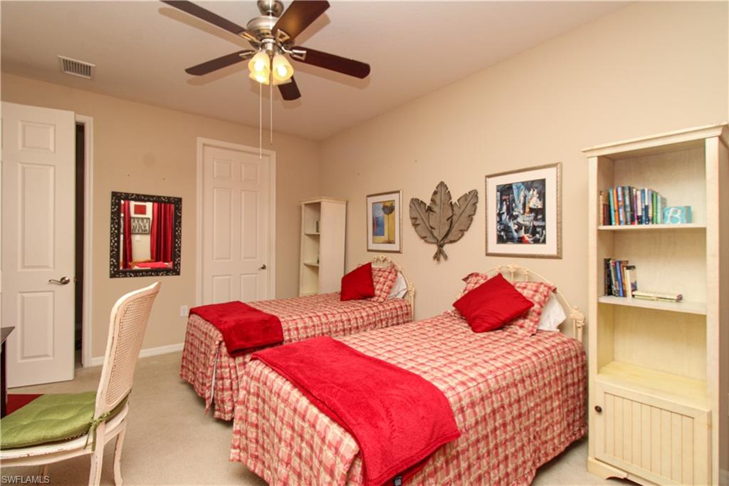 9054 Capistrano Street North, Unit 4003 Naples, FL 34113 - Photo 31 of 49 a bedroom with two bed and a chandelier