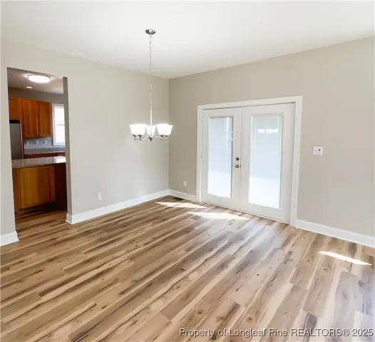 a view of a livingroom with wooden floor and kitchen