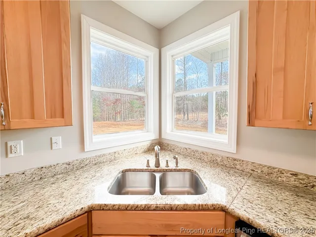 a kitchen with granite countertop a sink and a white cabinets