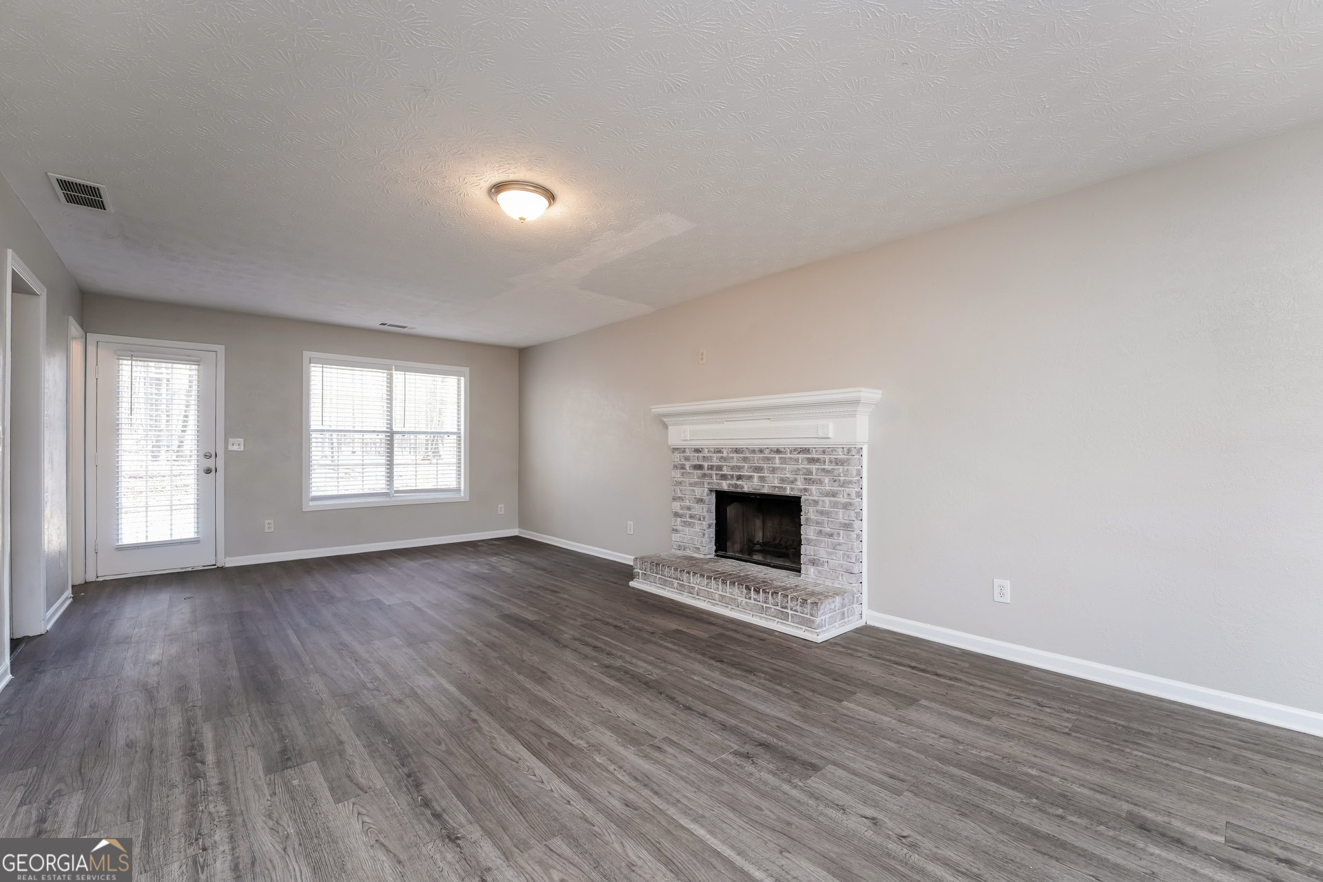 310 Alcovy Way Covington, GA 30014 - Photo 5 of 22 a view of empty room with wooden floor and fireplace