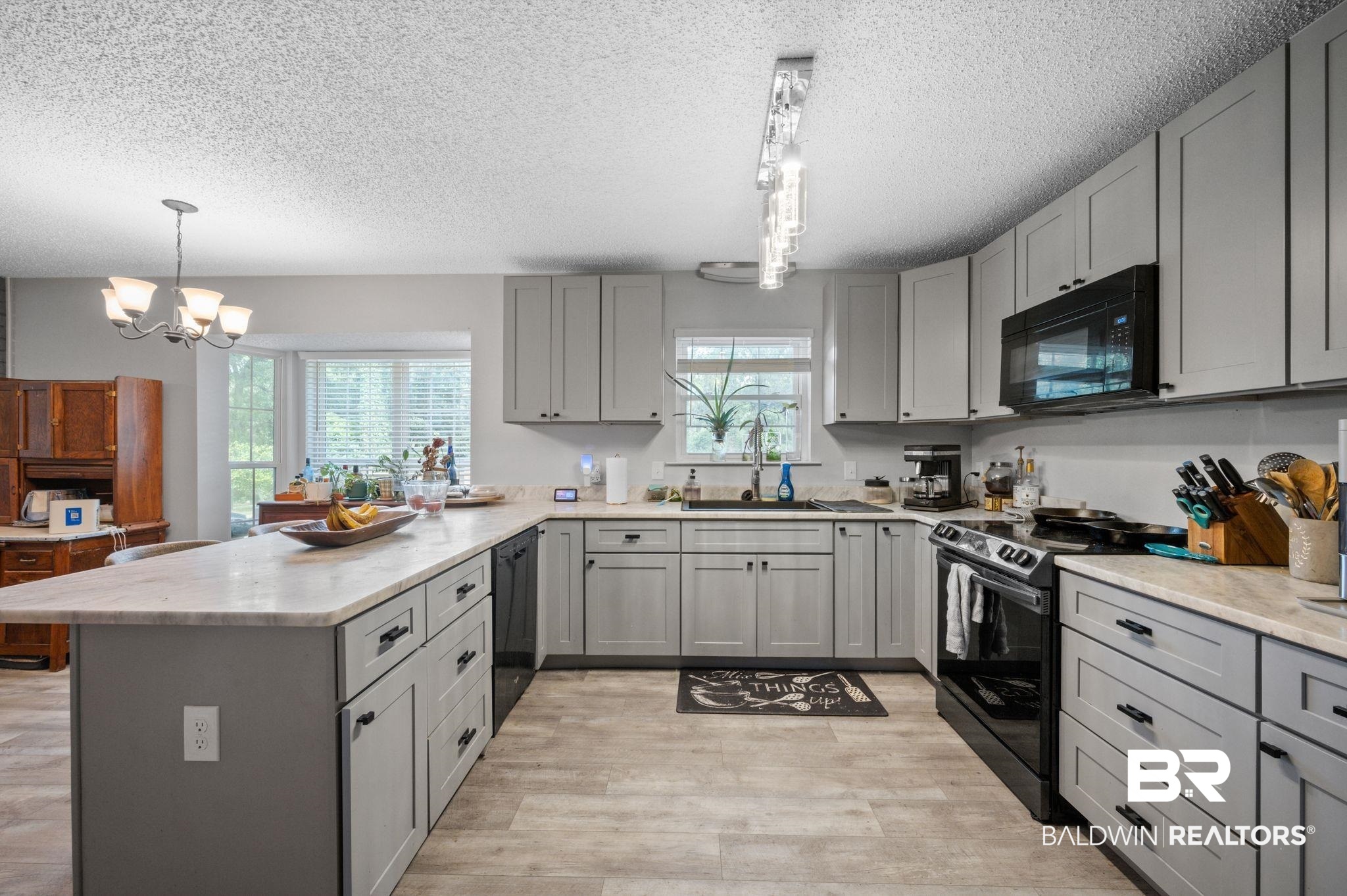 620 Southern Way Spanish Fort, AL 36527 - Photo 3 of 18 Kitchen with black appliances, gray cabinetry, sink, kitchen peninsula, and hanging light fixtures