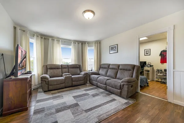 a living room with furniture flat screen tv and a window