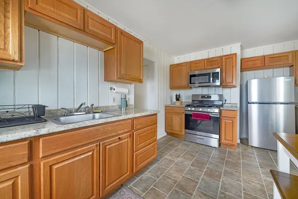 a kitchen with stainless steel appliances granite countertop a refrigerator and a stove top oven