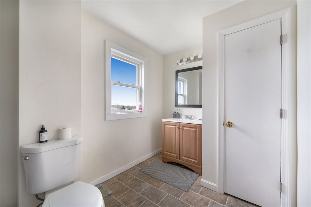 80 Lane Street, Unit 3 Fall River, MA 02721 - Photo 10 of 11 a bathroom with a granite countertop toilet a sink and mirror