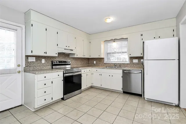 a kitchen with white cabinets and white appliances