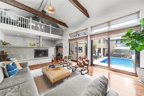 a living room with fireplace furniture and a large window