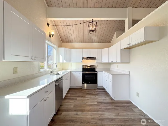 a view of a hallway with wooden floor and entryway