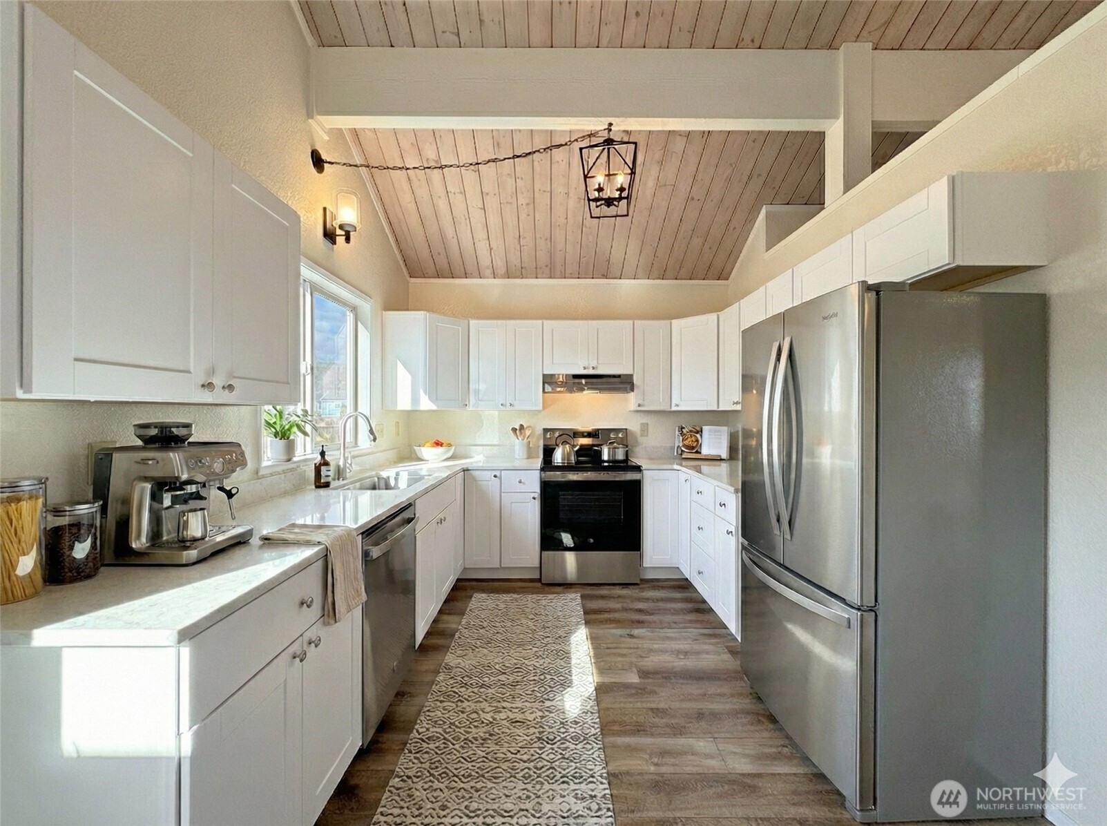 1212 Craig Avenue, Unit 3 Port Angeles, WA 98362 - Photo 12 of 38 a kitchen with stainless steel appliances a refrigerator a sink dishwasher a stove and white cabinets with wooden floor
