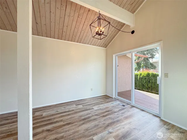 a view of a hallway with wooden floor and a bathroom
