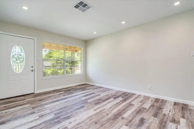 wooden floor in an empty room with a window