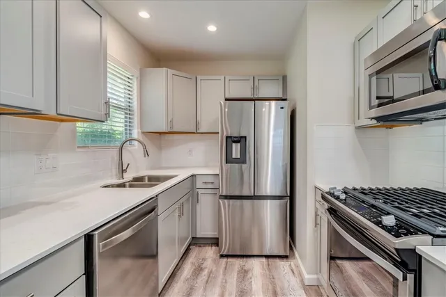 a kitchen with a refrigerator stove and sink
