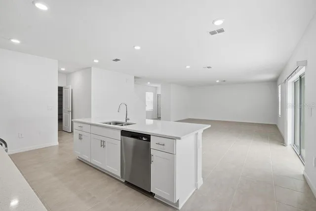 a kitchen with sink and white cabinets
