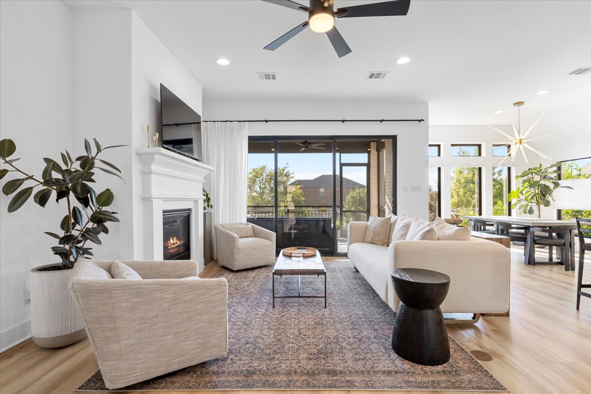 398 Trout River Road Kyle, TX 78640 - Photo 1 of 40 Living area featuring a ceiling fan, light wood finished floors, a glass covered fireplace, and recessed lighting