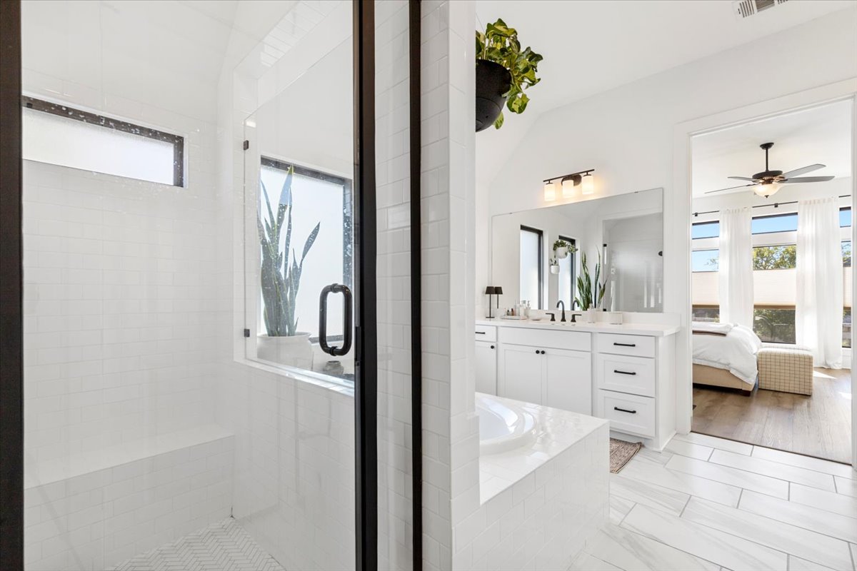 398 Trout River Road Kyle, TX 78640 - Photo 20 of 40 Ensuite bathroom featuring vanity, plenty of natural light, a shower stall, a bath, and lofted ceiling