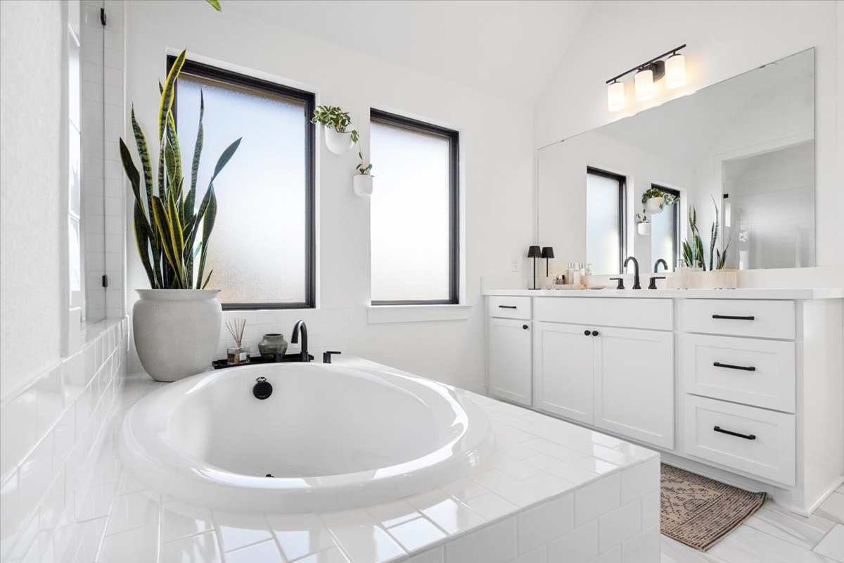 398 Trout River Road Kyle, TX 78640 - Photo 22 of 40 Full bathroom with vanity, vaulted ceiling, and a bath
