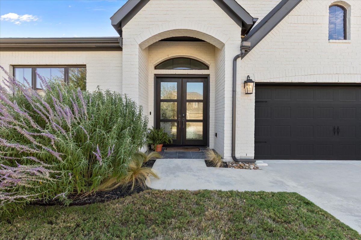 398 Trout River Road Kyle, TX 78640 - Photo 5 of 40 View of exterior entry with french doors, brick siding, and driveway