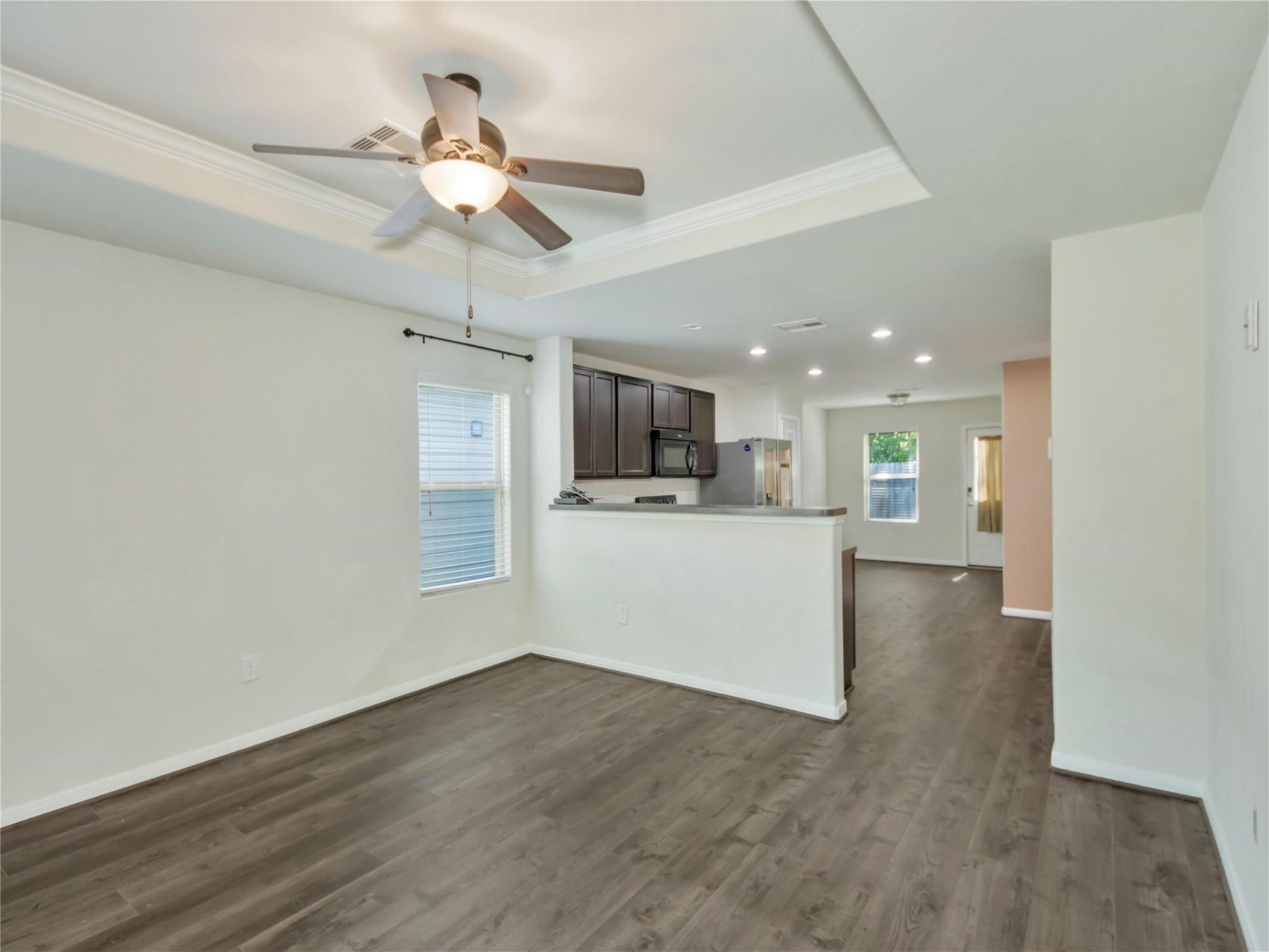 9906 Orchid Spring Lane Houston, TX 77044 - Photo 14 of 27 a view of a kitchen with a sink a refrigerator a ceiling fan and wooden floor