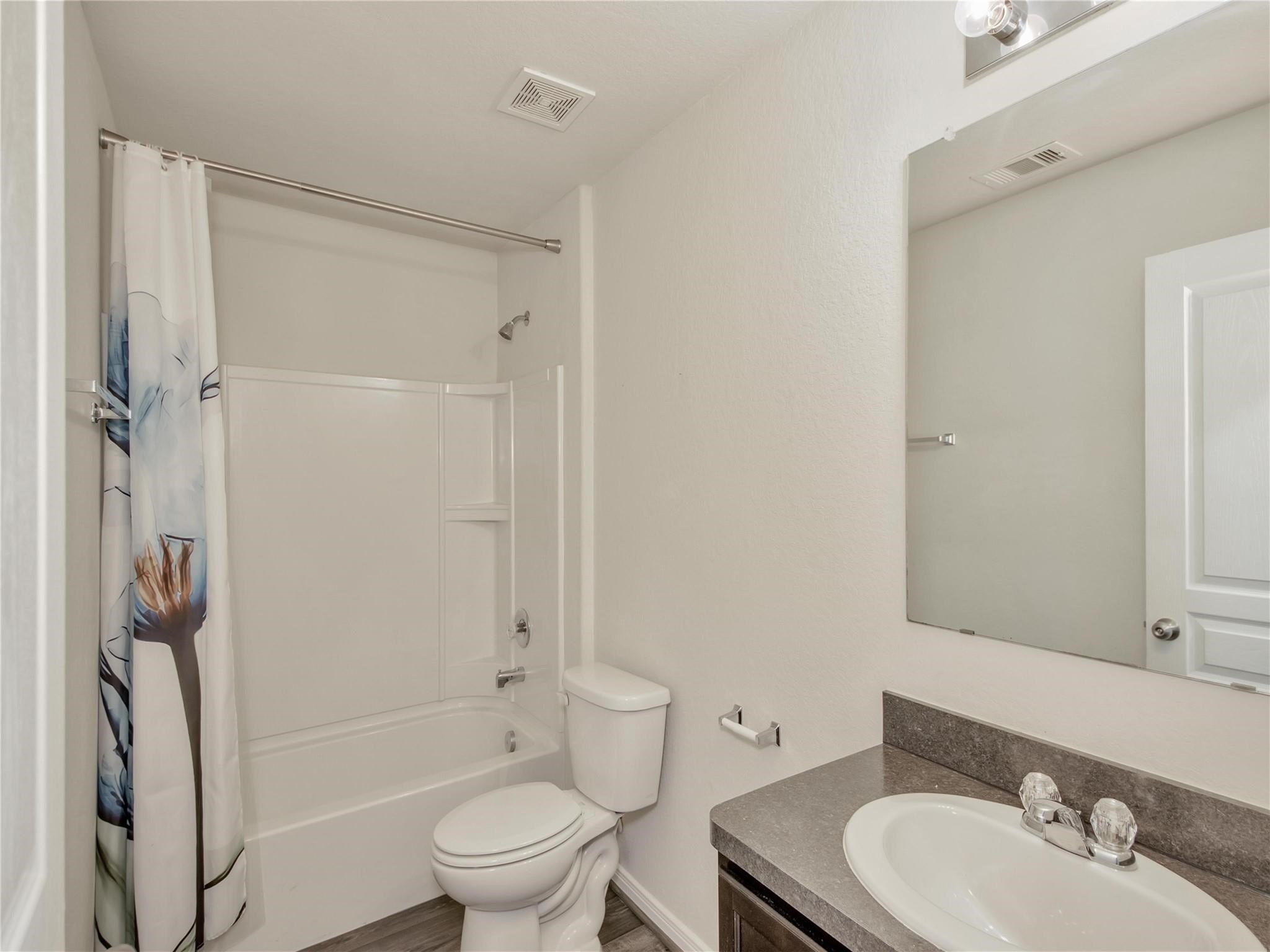 9906 Orchid Spring Lane Houston, TX 77044 - Photo 17 of 27 a bathroom with a granite countertop sink toilet and shower