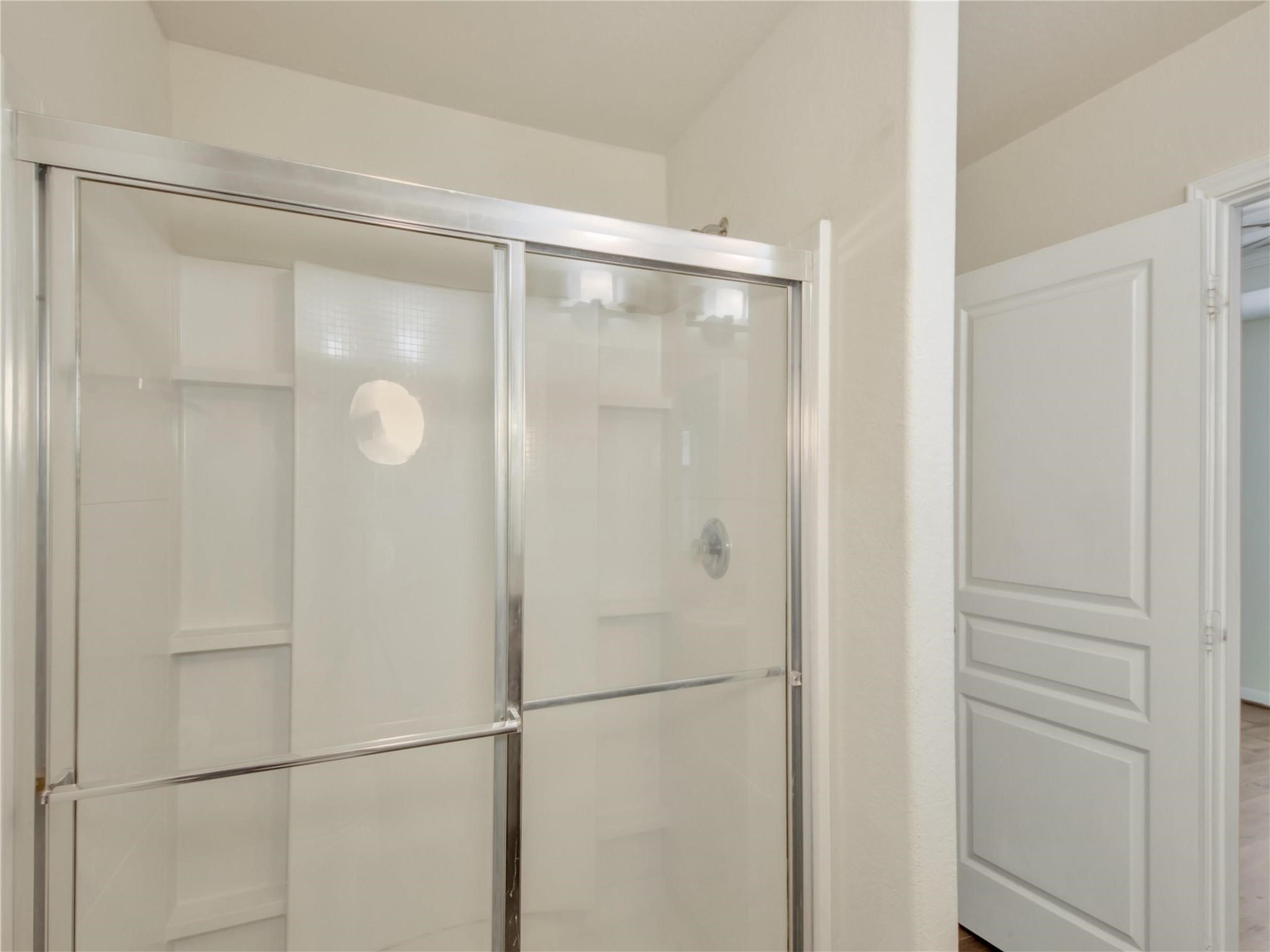 9906 Orchid Spring Lane Houston, TX 77044 - Photo 20 of 27 a bathroom with a glass shower door