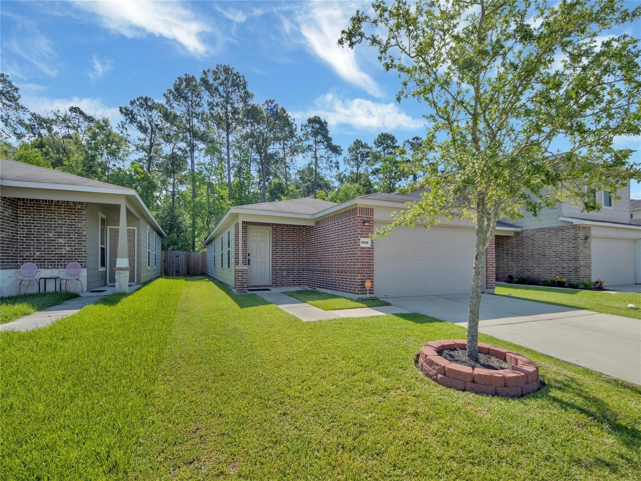 9906 Orchid Spring Lane Houston, TX 77044 - Photo 2 of 27 a backyard of a house with a fountain and a large tree