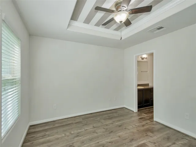 an empty room with fan and windows