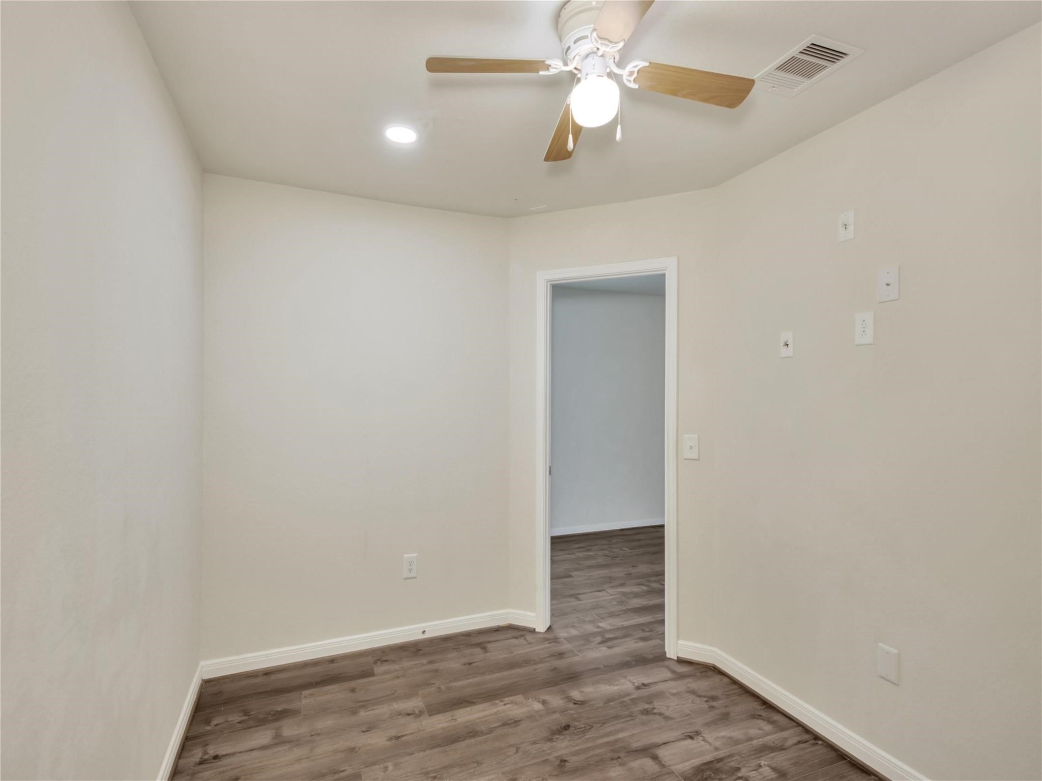 9906 Orchid Spring Lane Houston, TX 77044 - Photo 8 of 27 en empty room with wooden floor and ceiling fan