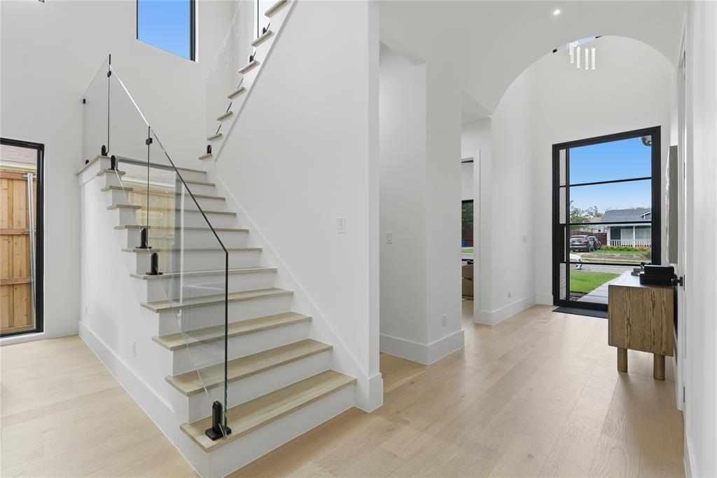 6038 Prospect Avenue Dallas, TX 75206 - Photo 8 of 40 Grand entryway featuring a contemporary staircase with glass railings and wood-finish treads