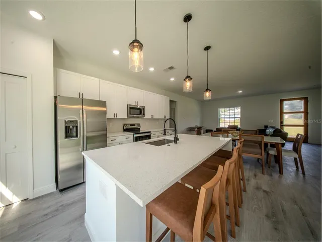 a large kitchen with a table and chairs