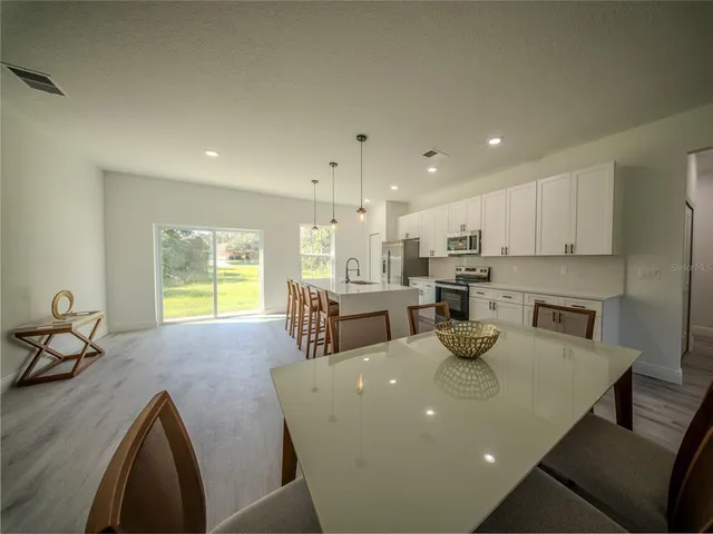 a view of a dining room with furniture and a kitchen