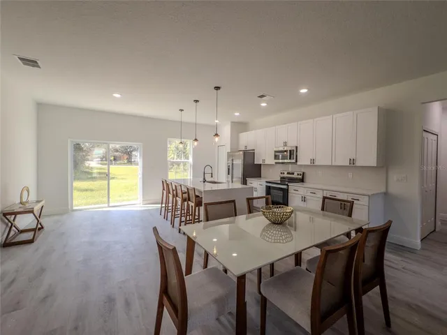 a view of a dining room and livingroom with furniture window and wooden floor
