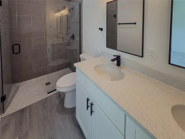 a bathroom with a sink a toilet and shower