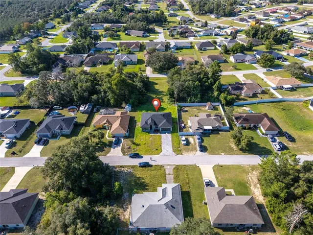 an aerial view of residential houses with outdoor space and swimming pool