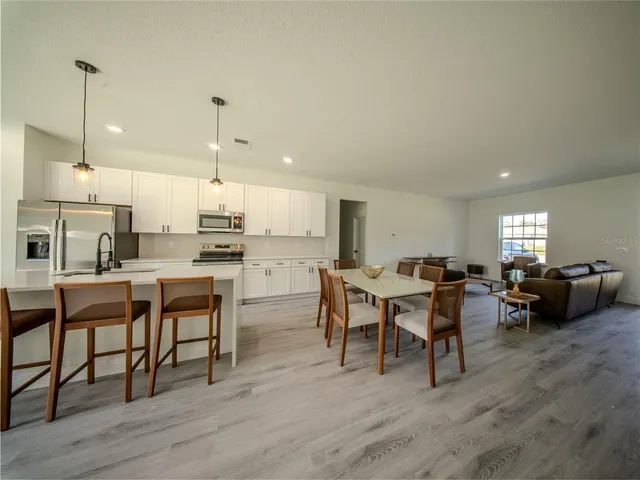 a living room with lots of furniture and kitchen view