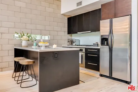 a kitchen with stainless steel appliances a sink a table and chairs